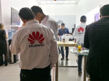 Medellin, Colombia - 10/05/2018: Huawei staff in a store of this Chinese technology brand. People buying smartphones. clipart