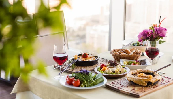 Kızarmış yumurta, salata et yemeği ve restoranda şarap.