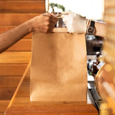 İşçi müşteriye hazır yiyecek torbası veriyor