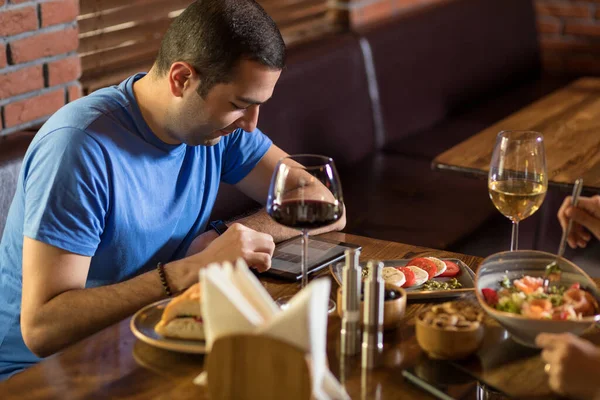 Hombre Mirando Menú Del Restaurante Tableta Copas Vino Mesa — Foto de Stock