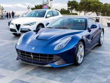 Mavi Ferrari diğer spor arabalarla sergide.