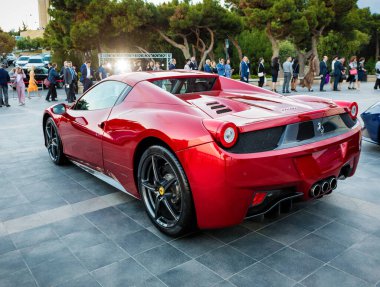 Kırmızı Ferrari diğer spor arabalarla sergide.