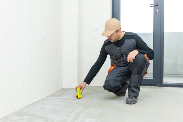 Hombre probando la humedad en una pared con un medidor de humedad