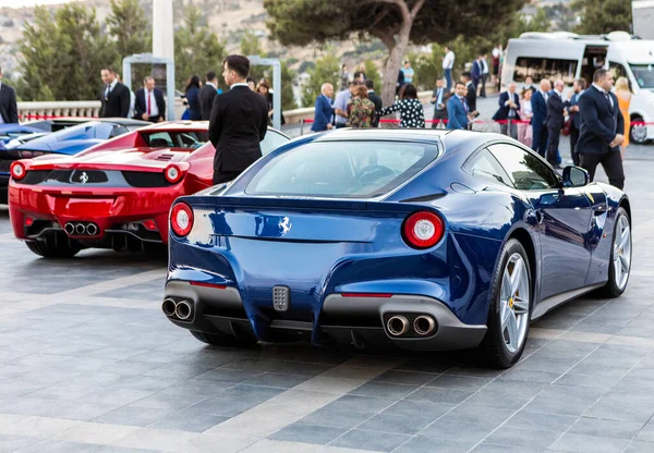 Mavi Ferrari diğer spor arabalarla sergide.