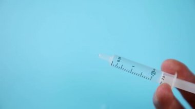 Doktorun elinde iğne ve ampulle ilaç aşı ekipmanı.