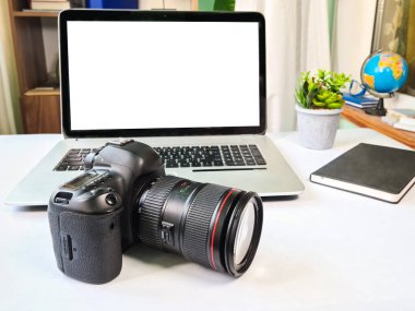 Fotoğraf masası, masada dizüstü bilgisayarı olan profesyonel bir kamera.