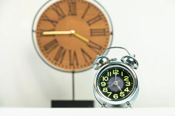 Shiny alarm clock with wood clock background isolated white background