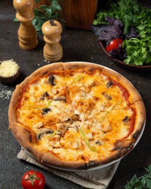 Freshly baked pizza with melted cheese, chicken, mushrooms, and green peppers, creating a tempting culinary experience