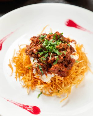 Geleneksel Türk yemeği yoğurt, kızarmış patates ve maydanoz ve baharatla süslenmiş et.