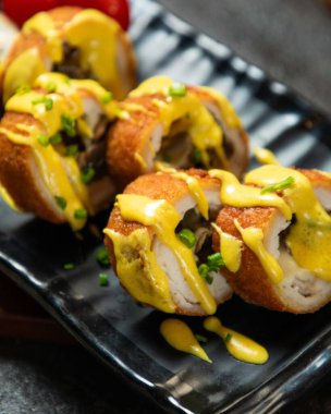 Delicious breaded chicken rolls stuffed with mushrooms, cheese and mustard sauce, garnished with chives