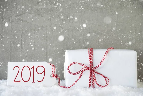 Подарунок, фон цементу зі сніжинками, текст 2019 року, сніг — стокове фото
