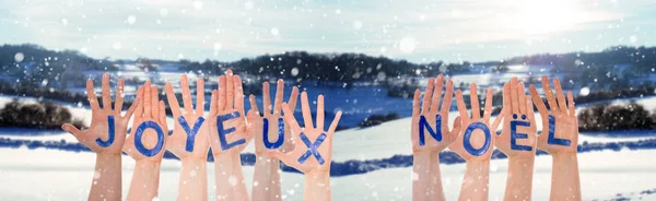 Molte mani che costruiscono Joyeux Noel significa Buon Natale, scenario invernale — Foto Stock