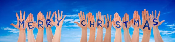 Många händer bygga ordet god jul, blå himmel — Stockfoto