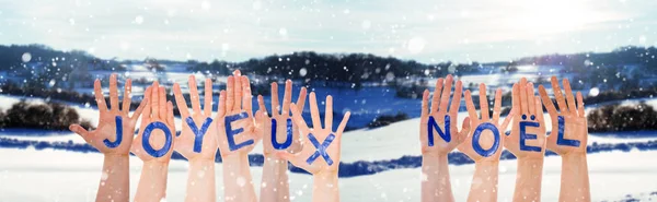 Många händer bygga Joyeux Noel betyder god jul, vinter landskap — Stockfoto