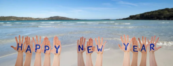 Molte mani che costruiscono parola Felice anno nuovo, spiaggia e oceano — Foto Stock