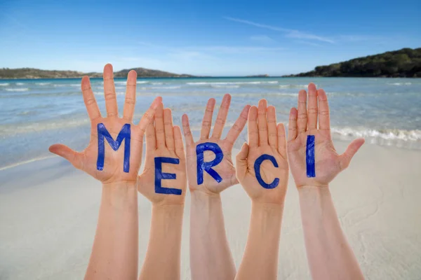 Большое количество рук для строительства Merci означает "Спасибо", пляж и океан — стоковое фото