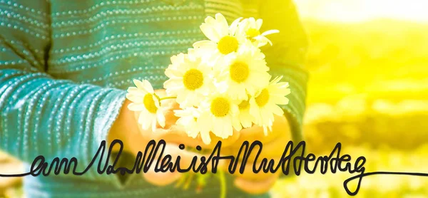 Дитина, букет з ромашки квітка, каліграфії Muttertag означає щасливі матері день — стокове фото