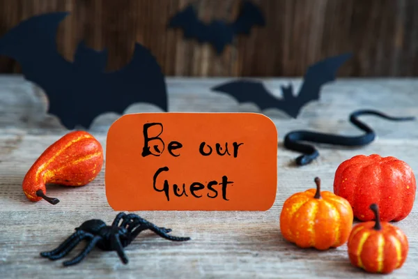 Oranssi etiketti, teksti olla vieraamme, pelottava Halloween koristelu — kuvapankkivalokuva