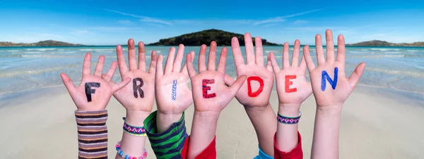 Kinderen handen bouwen woord Frieden betekent vrede, oceaan achtergrond — Stockfoto