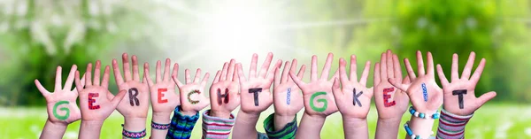 Dzieci Hands Building Word Gerechtigkeit oznacza sprawiedliwość, łąka trawy — Zdjęcie stockowe