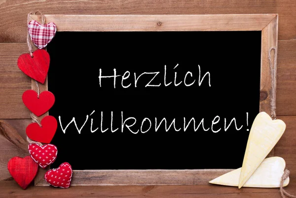 Балкборд с украшением сердца, текст Herzlich Willkommen означает добро пожаловать — стоковое фото