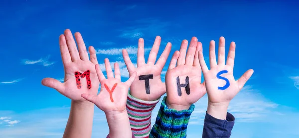 Manos de niños sosteniendo mitos de la palabra, cielo azul — Foto de Stock