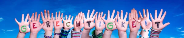 Kinderhände Wortbildung bedeutet Gerechtigkeit, blauer Himmel — Stockfoto