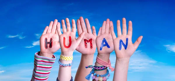 Las manos de los niños Construyendo Palabra Humano, Cielo Azul — Foto de Stock