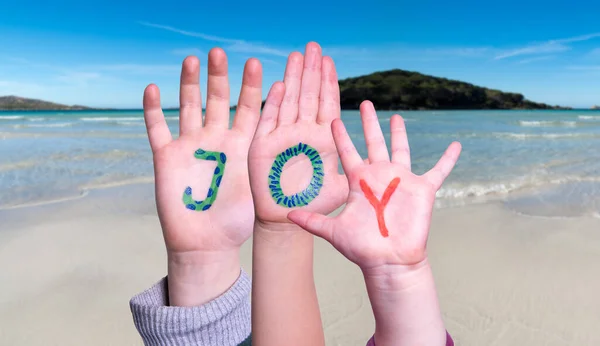 Bambini mani costruire parola gioia, sfondo dell'oceano — Foto Stock