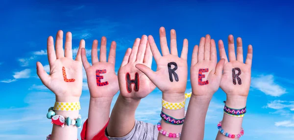 Gyermekek kéz épület Word Lehrer azt jelenti, tanár, kék ég — Stock Fotó