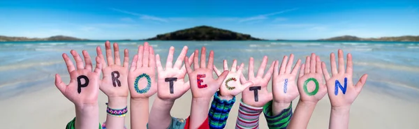 Mani dei bambini che tengono la protezione della parola, sfondo dell'oceano — Foto Stock