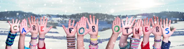 Crianças mãos construindo cuidados com a palavra para os outros, fundo de inverno nevado — Fotografia de Stock