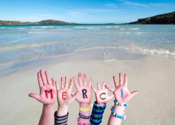 子供たちの手を構築する単語のメルシー手段ありがとう,海の背景 — ストック写真