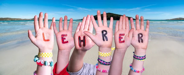 Kinderhände Wortbildung Lehrer bedeutet Lehrer, Ozeanhintergrund — Stockfoto