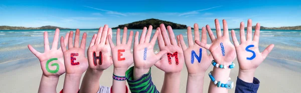 Barn händer bygga ord Geheimnis innebär hemlighet, Ocean Bakgrund — Stockfoto