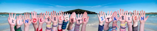 Руки, Kinderrechte Staerken означает укрепление прав детей, океан фон — стоковое фото