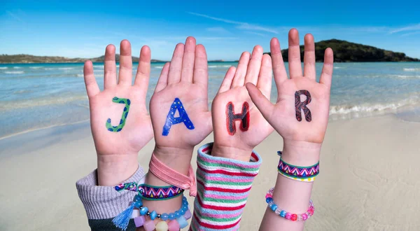 Barn händer bygga ord Jahr innebär år, Ocean bakgrund — Stockfoto