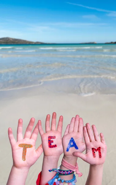 Mani dei bambini che costruiscono Word Team, sfondo oceano — Foto Stock