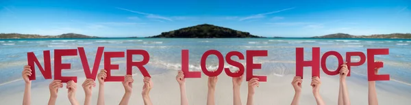Människor händer håller ord Aldrig förlora hoppet, Ocean Bakgrund — Stockfoto
