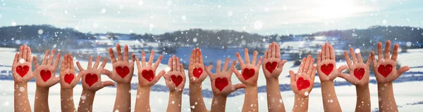 儿童的手与心的象征，冬天的雪景作为背景 — 图库照片