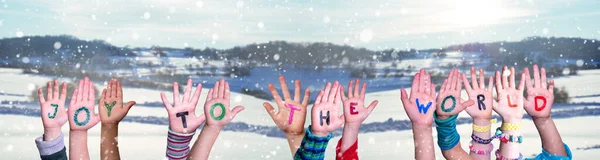 Crianças mãos construindo citar alegria para o mundo, fundo de inverno nevado — Fotografia de Stock