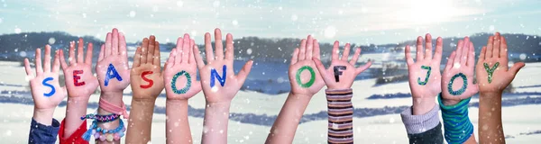 Barn händer bygga Word säsonger av glädje, snöig vinter bakgrund — Stockfoto