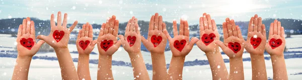 Παιδιά χέρια με το σύμβολο της καρδιάς και χαμόγελα, Χειμώνας Snow Scenerey ως φόντο — Φωτογραφία Αρχείου