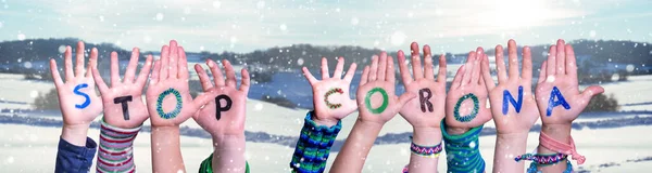 Barn händer håller Word Stop Corona, snöig vinter bakgrund — Stockfoto