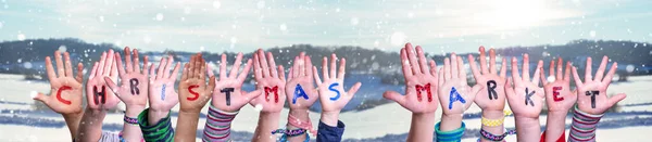 Niños Manos Construyendo Mercado de Navidad Palabra, Fondo de invierno nevado — Foto de Stock