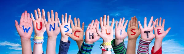 Kinderhände basteln Wortwunschliste bedeutet Wunschliste, blauer Himmel — Stockfoto