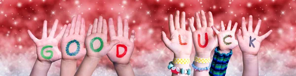 Crianças mãos construindo palavra boa sorte, fundo de Natal vermelho — Fotografia de Stock