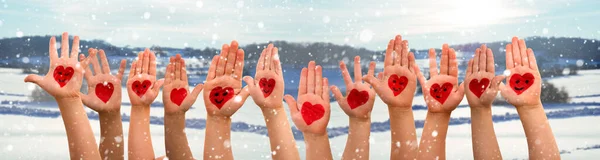 Gyerekek kéz szív szimbólummal és mosolygós, téli hó táj, mint a háttér — Stock Fotó