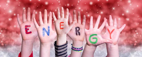 Gyerekek kezek épület Word Energy, piros karácsonyi háttér — Stock Fotó