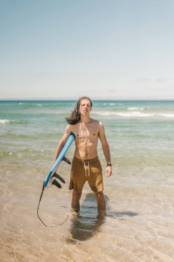 Okyanusta Sörf tahtası konumu yaz gününde olan genç adam